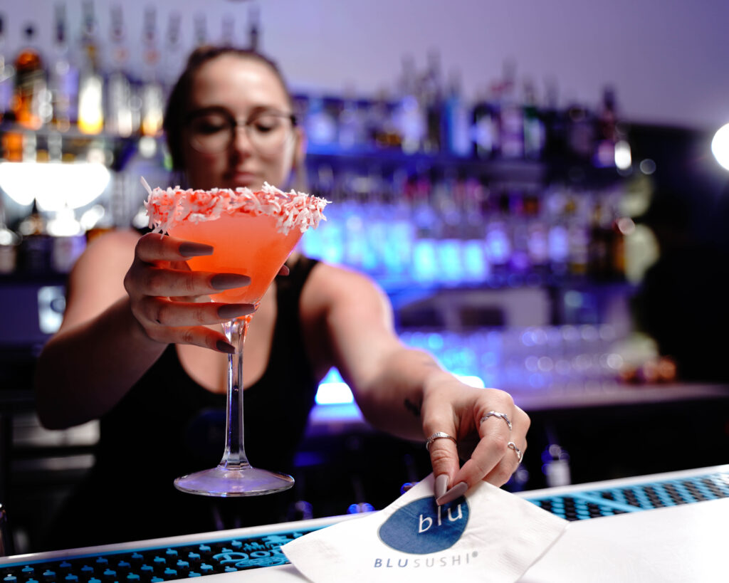 Bartender serving a Coco Pink Chanel cocktail at Blu Sushi in Fort Myers, Florida